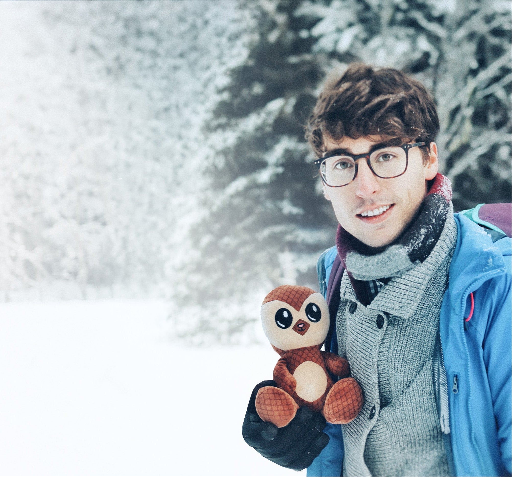 Person holding a stuffed animal in a snowy landscape